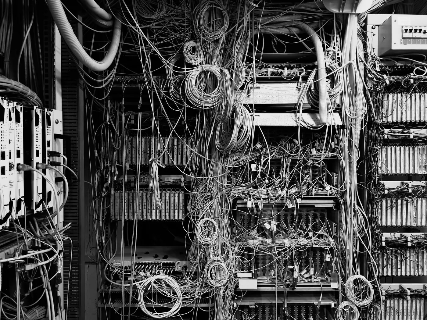 Une armoire de brassage télécom dont les câbles partent dans tous les sens, sans étiquette, entremêlés au point qu’aucun trajet ne se suit à l’œil.